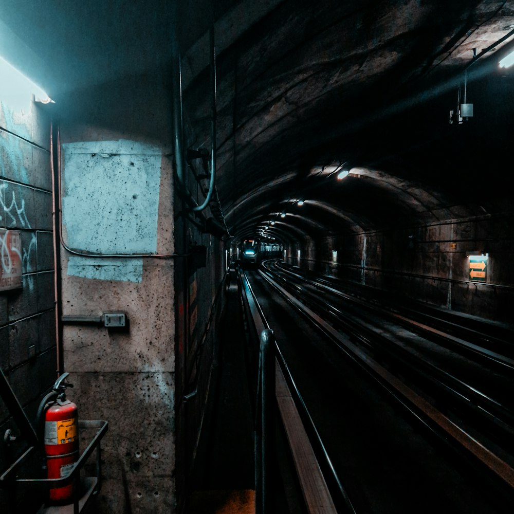 a train traveling through a tunnel with graffiti on the walls