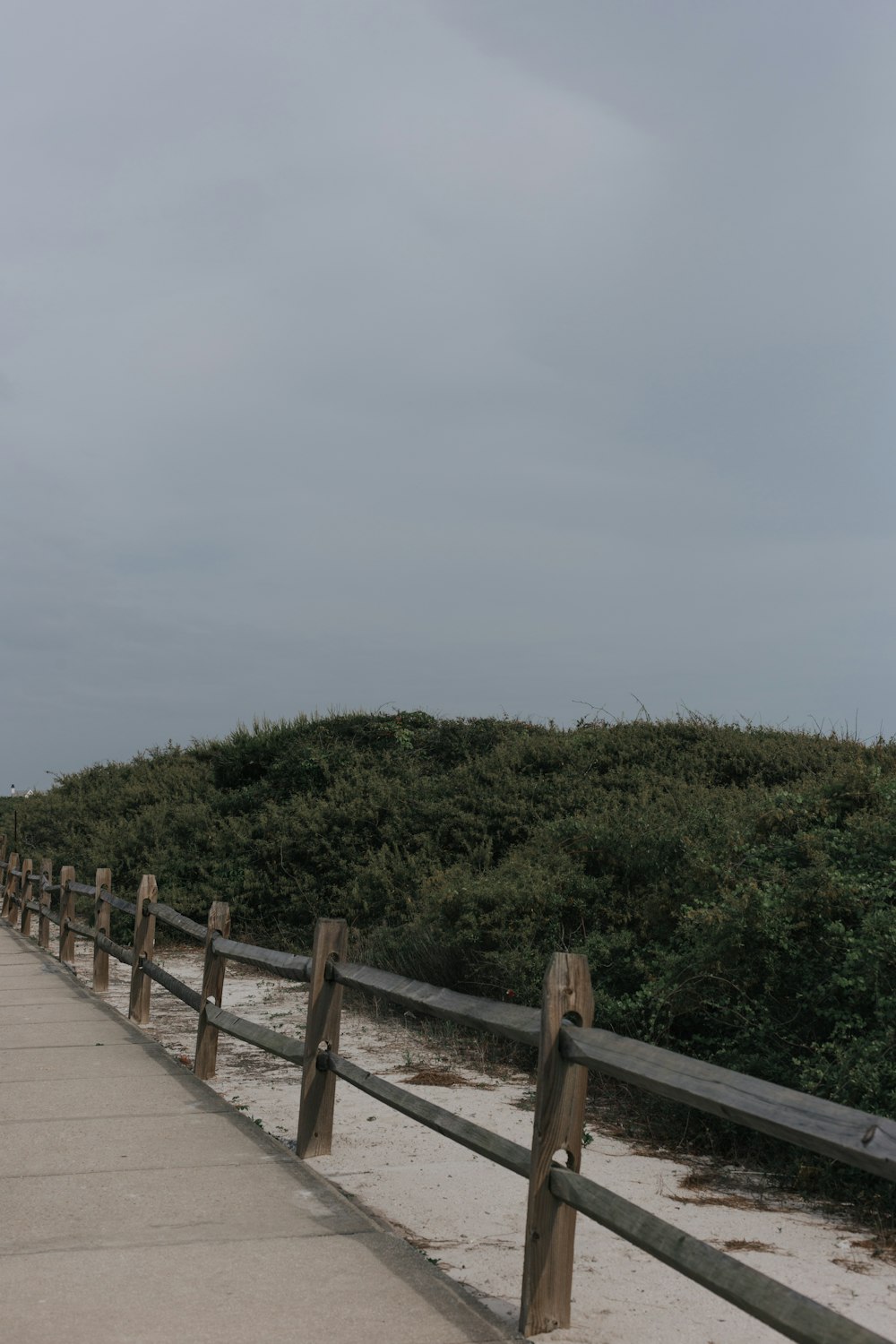 a wooden walkway leading to a grassy hill