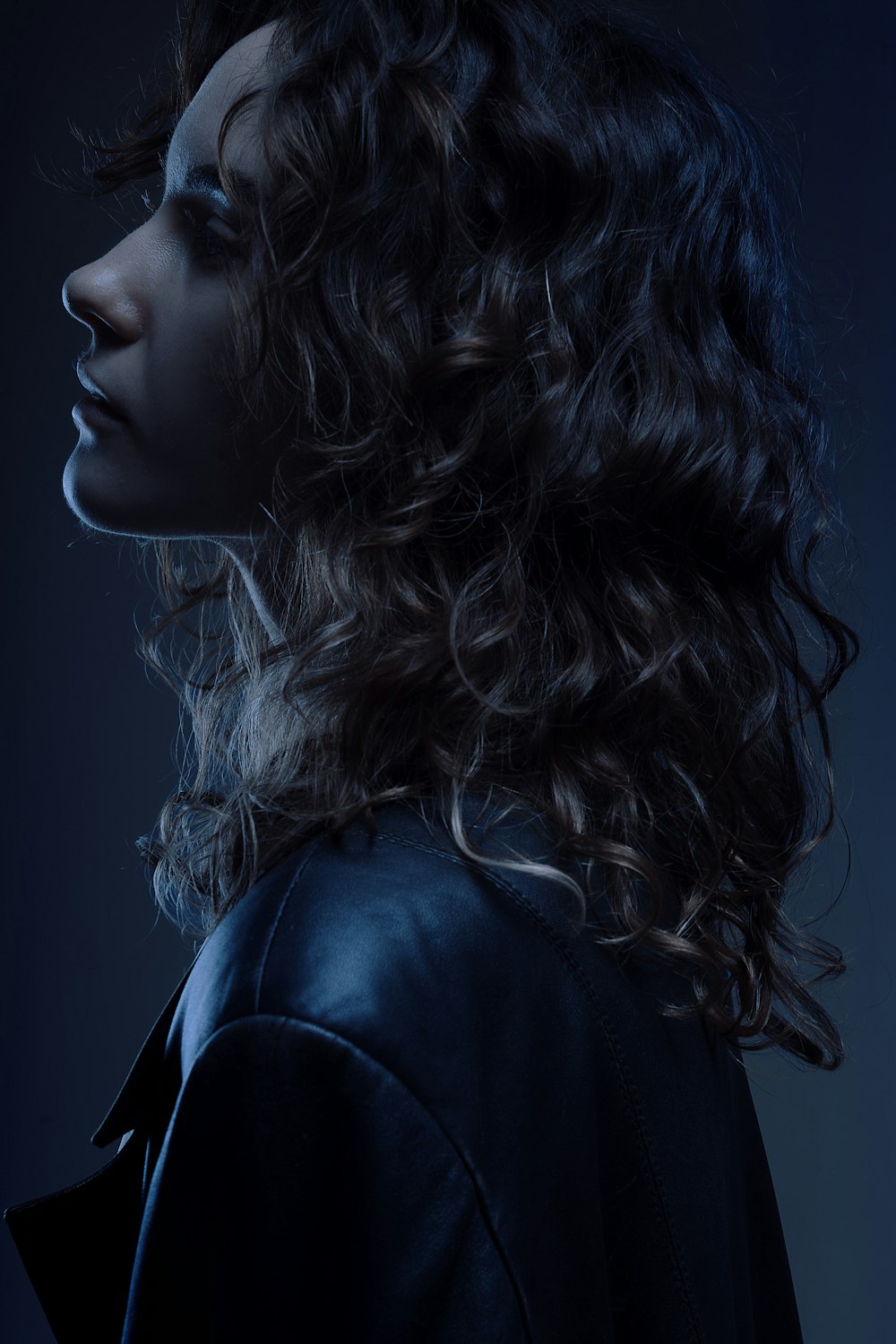 a woman with curly hair and a leather jacket