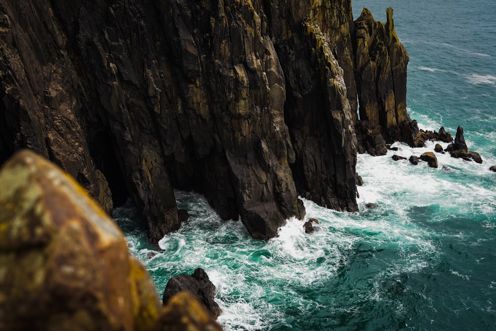 a large body of water next to a rocky cliff