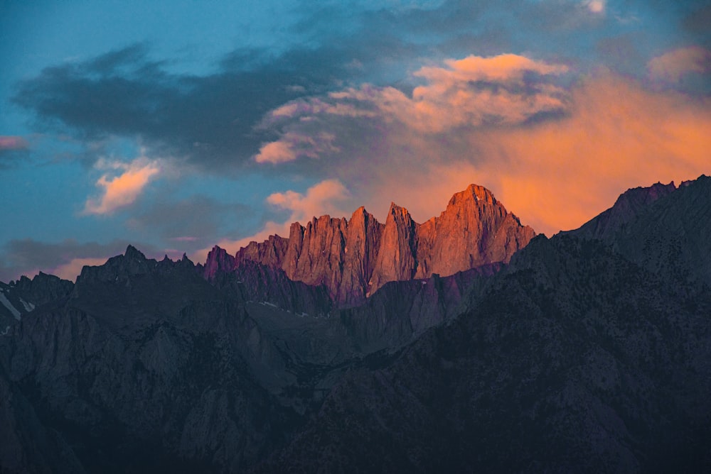 a very tall mountain with some clouds in the sky