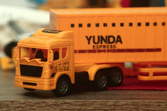 a yellow toy truck with a yellow trailer behind it