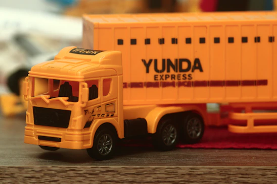 a yellow toy truck with a yellow trailer behind it
