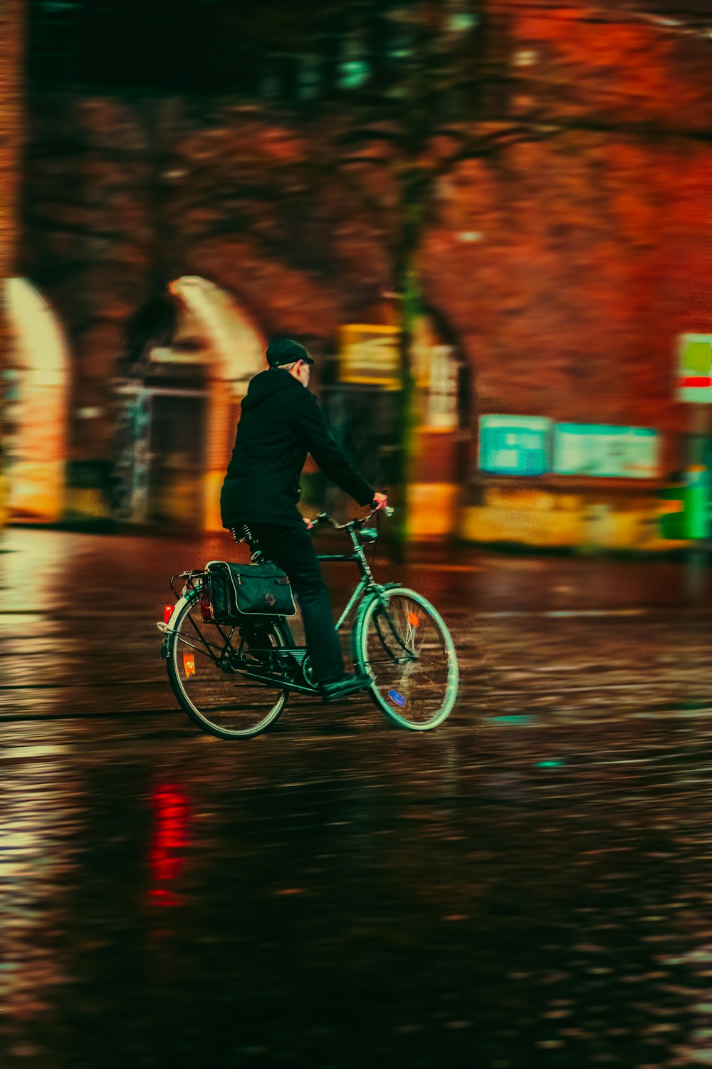 a man riding a bike down a street in the rain