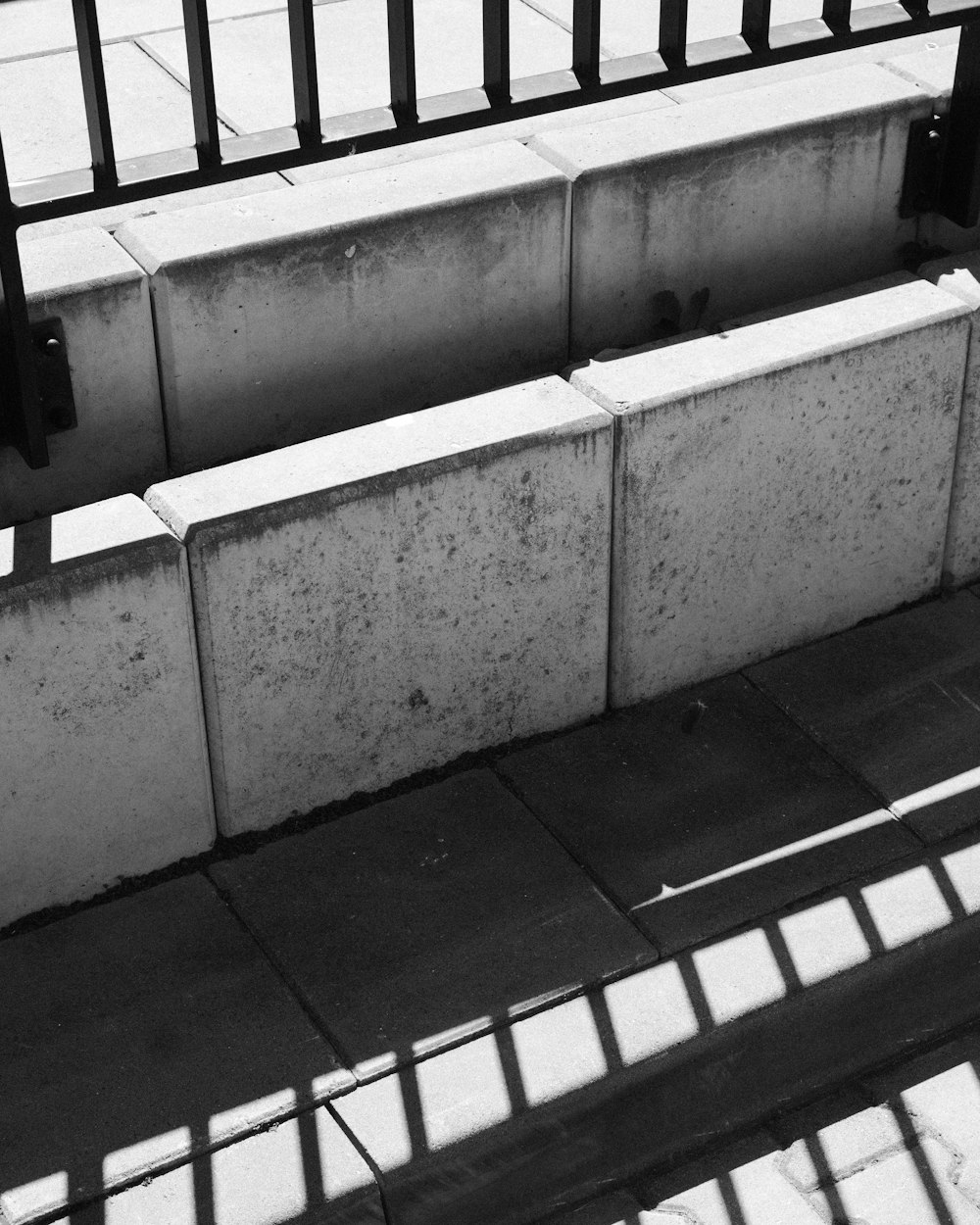 a black and white photo of a bench on a sidewalk