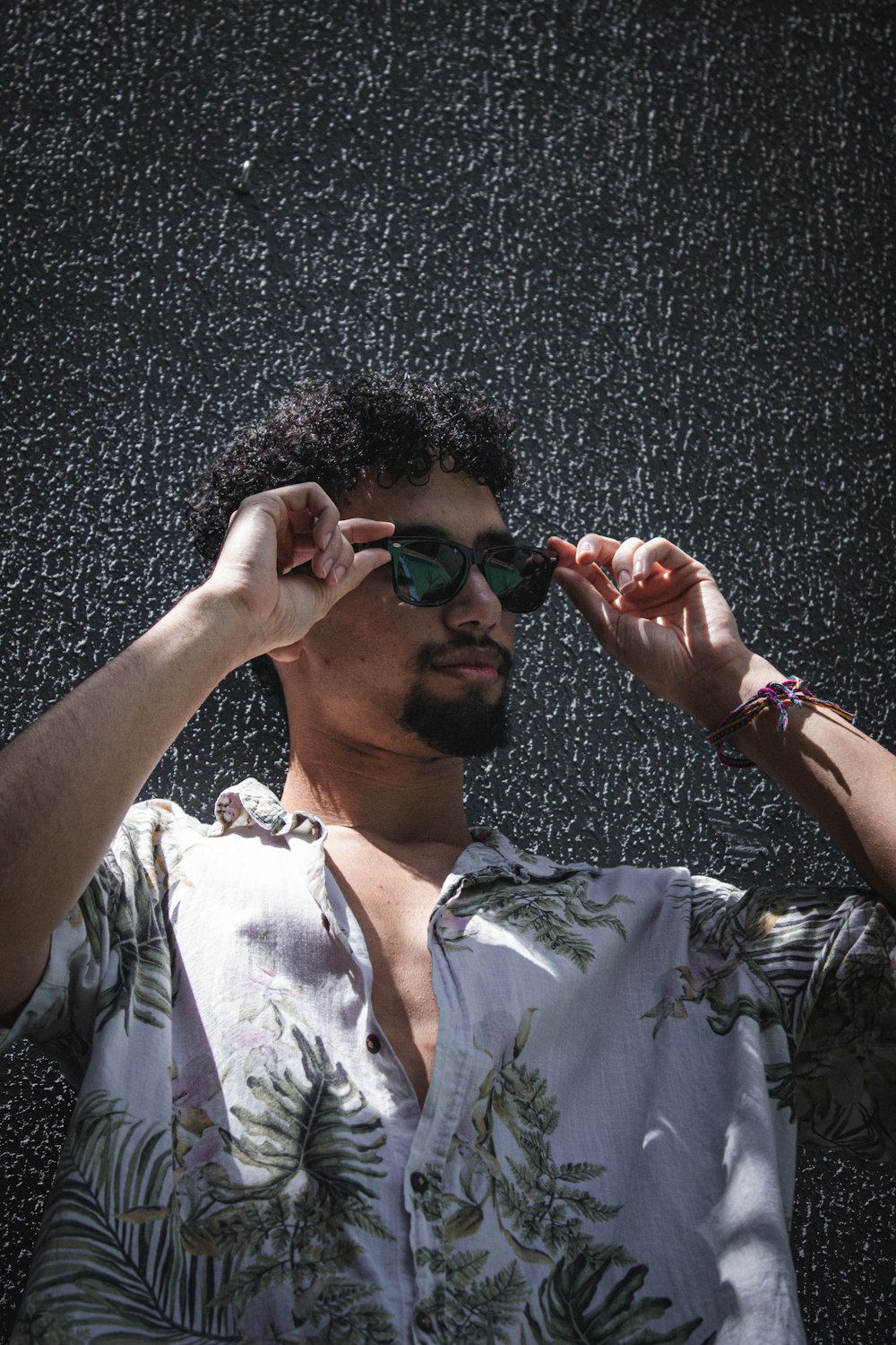 a man wearing sunglasses standing in the rain