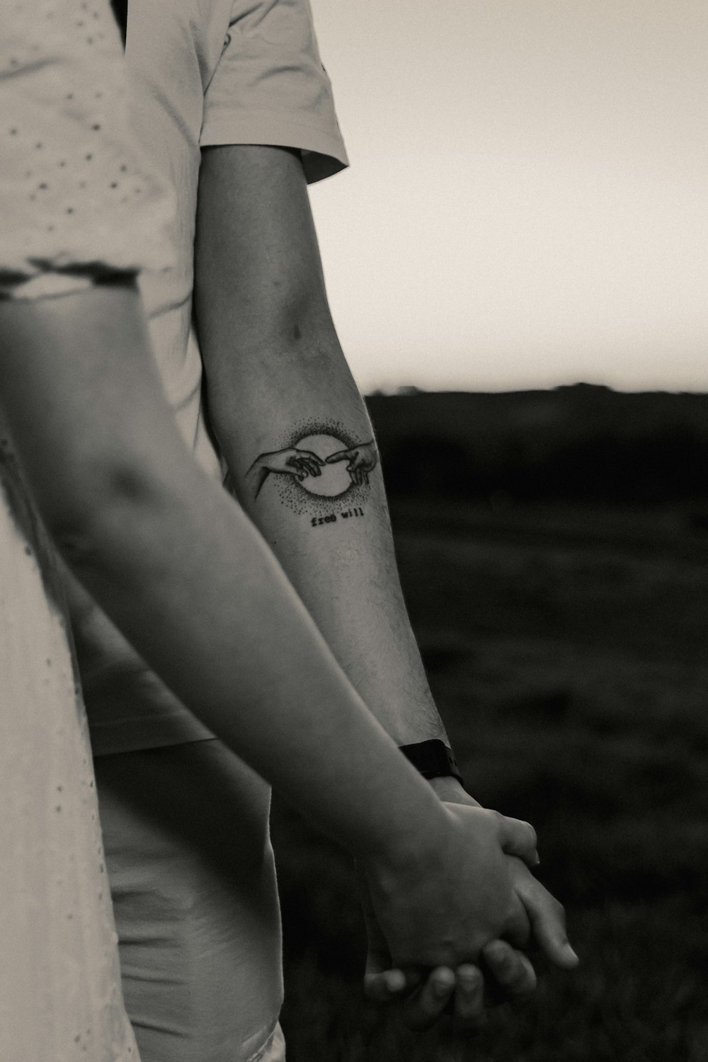 a couple holding hands with a tattoo on their arm