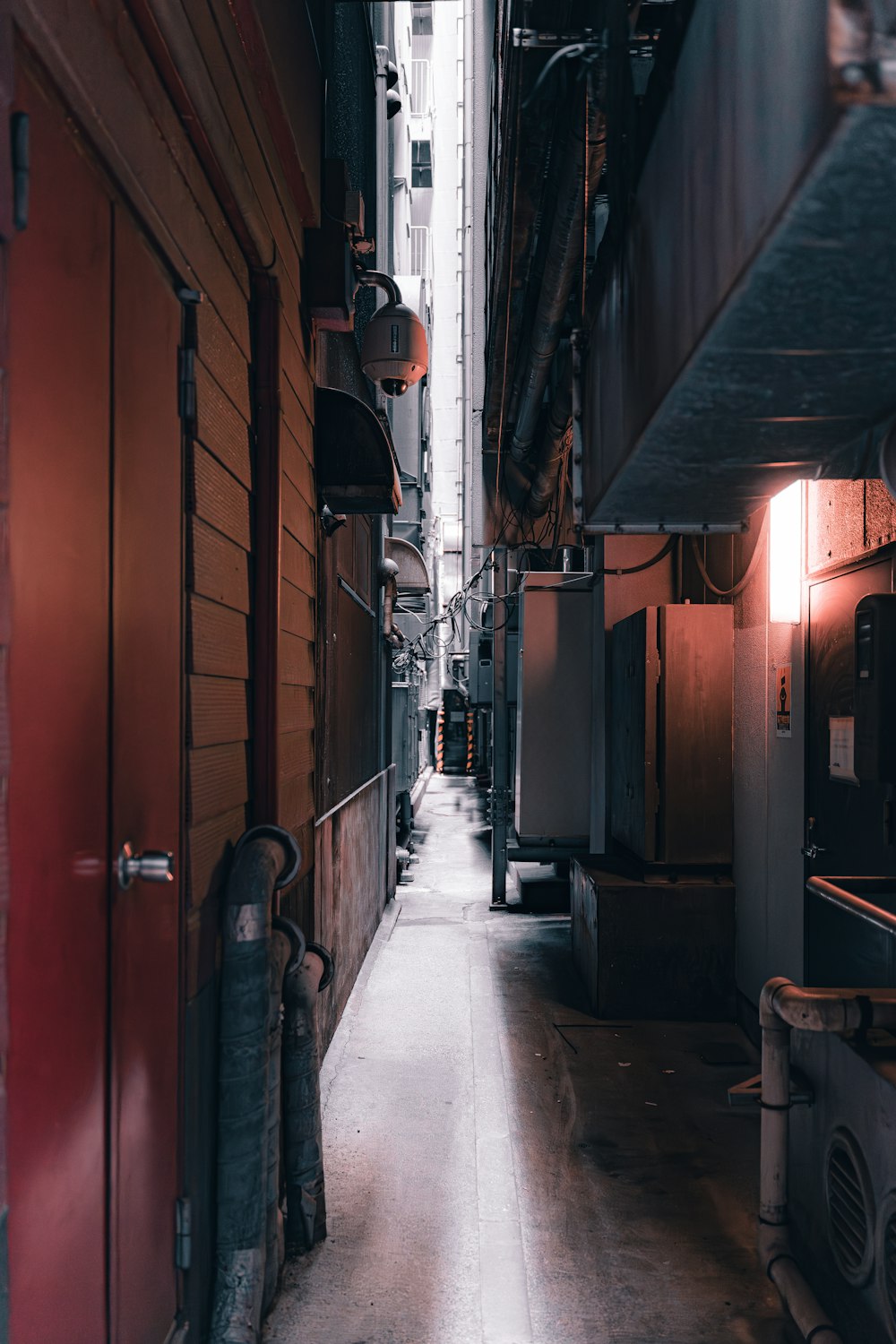 a narrow alley way with a red door