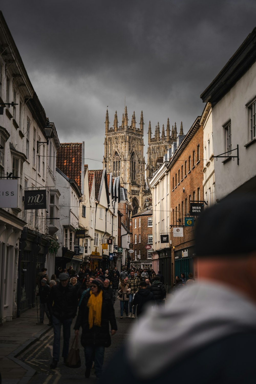 a group of people walking down a street next to tall buildings