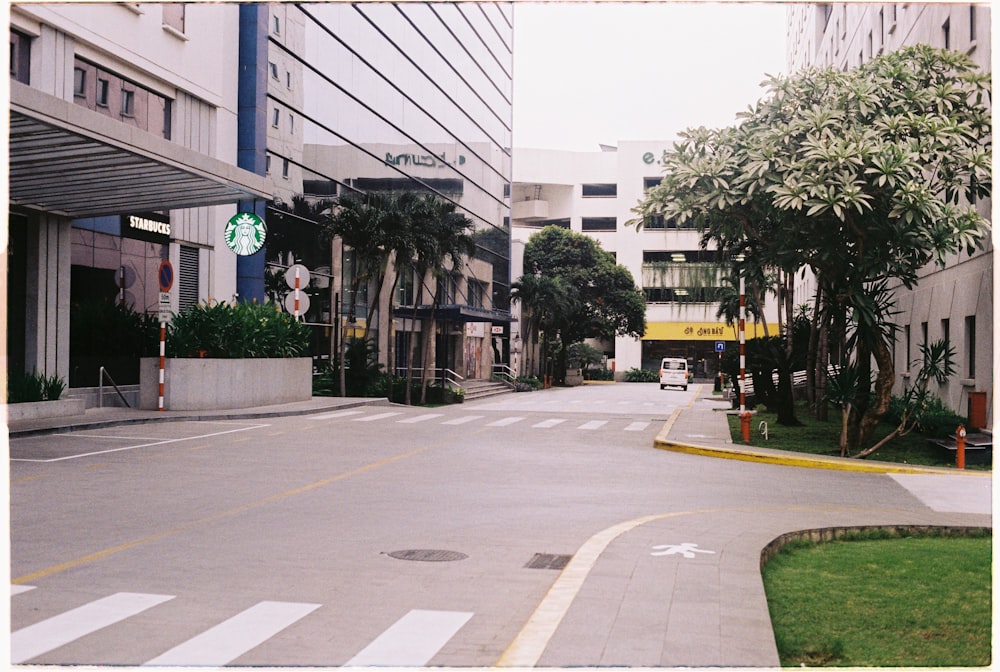 a city street with buildings and trees on both sides
