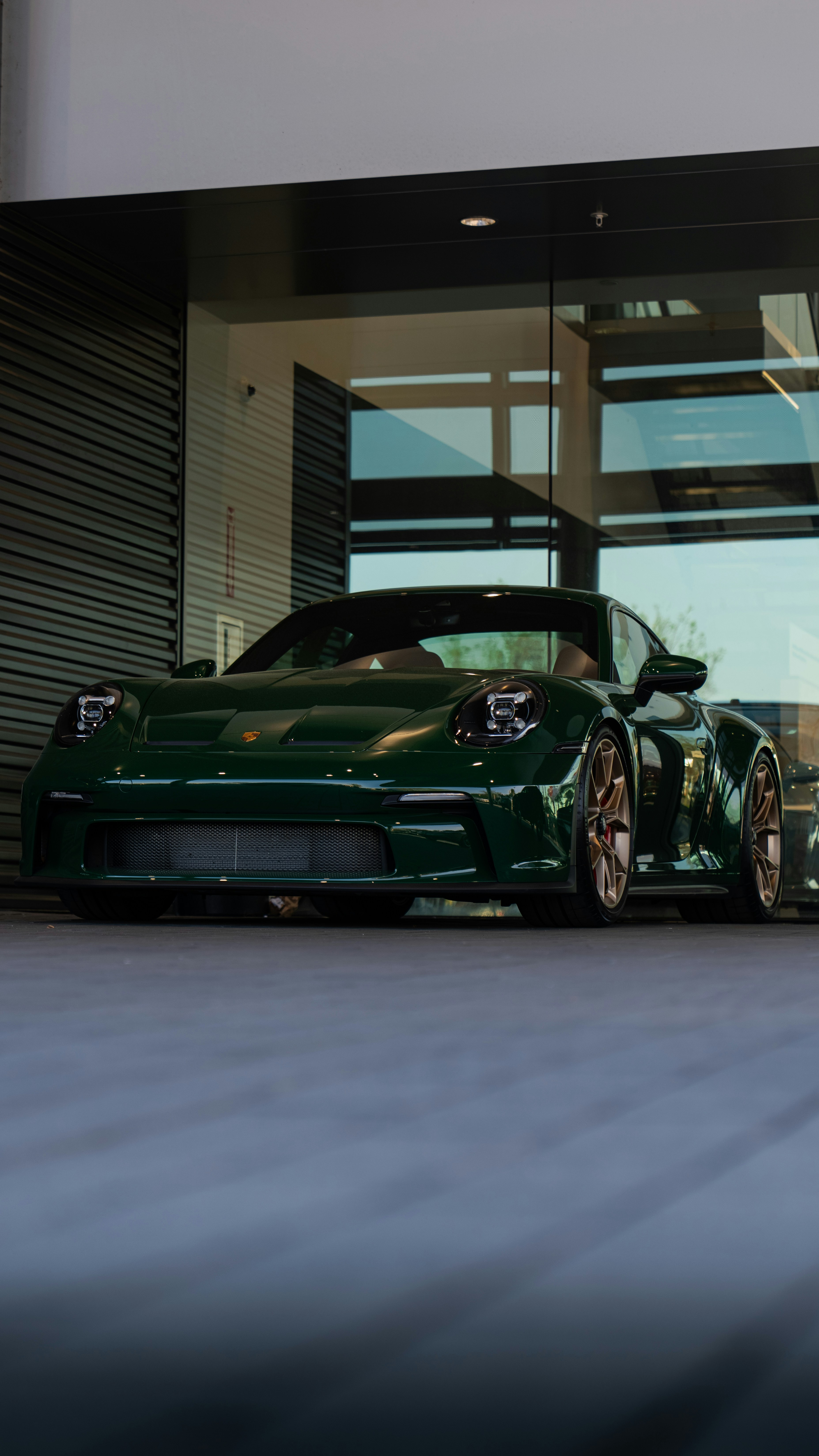 a green sports car parked in front of a building