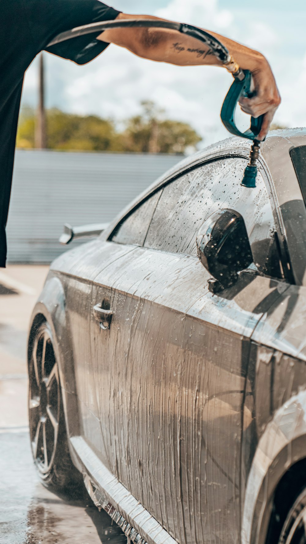 a person washing a car with a hose