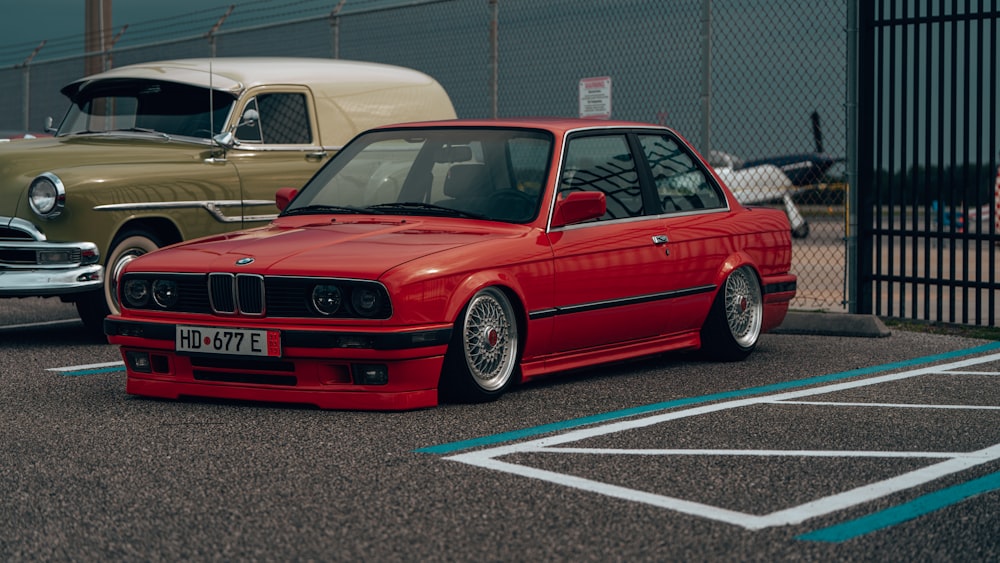 a red car parked in a parking lot next to other cars