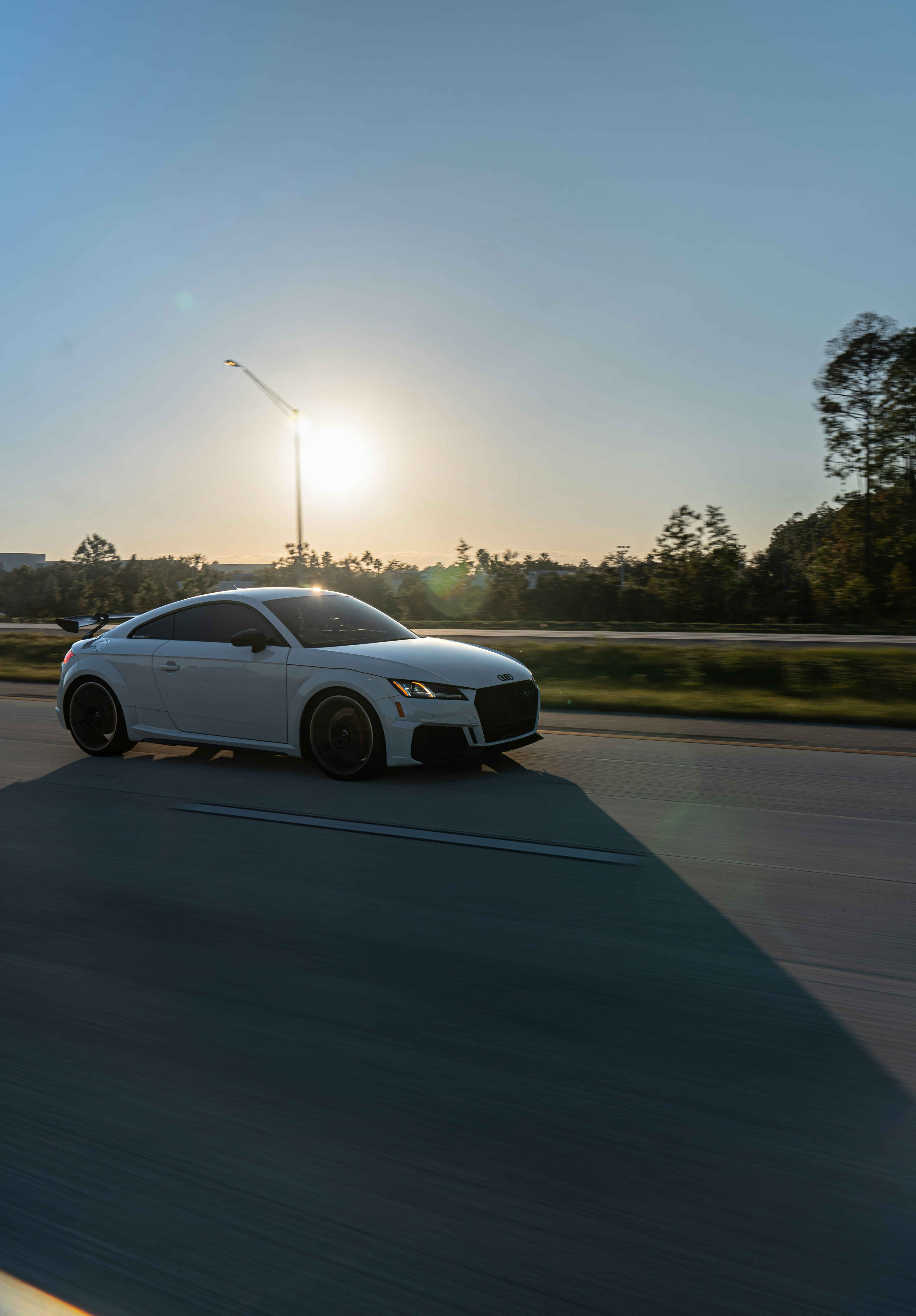 Modern vehicle on an open road at golden hour, scenic Georgia countryside, bright natural lighting