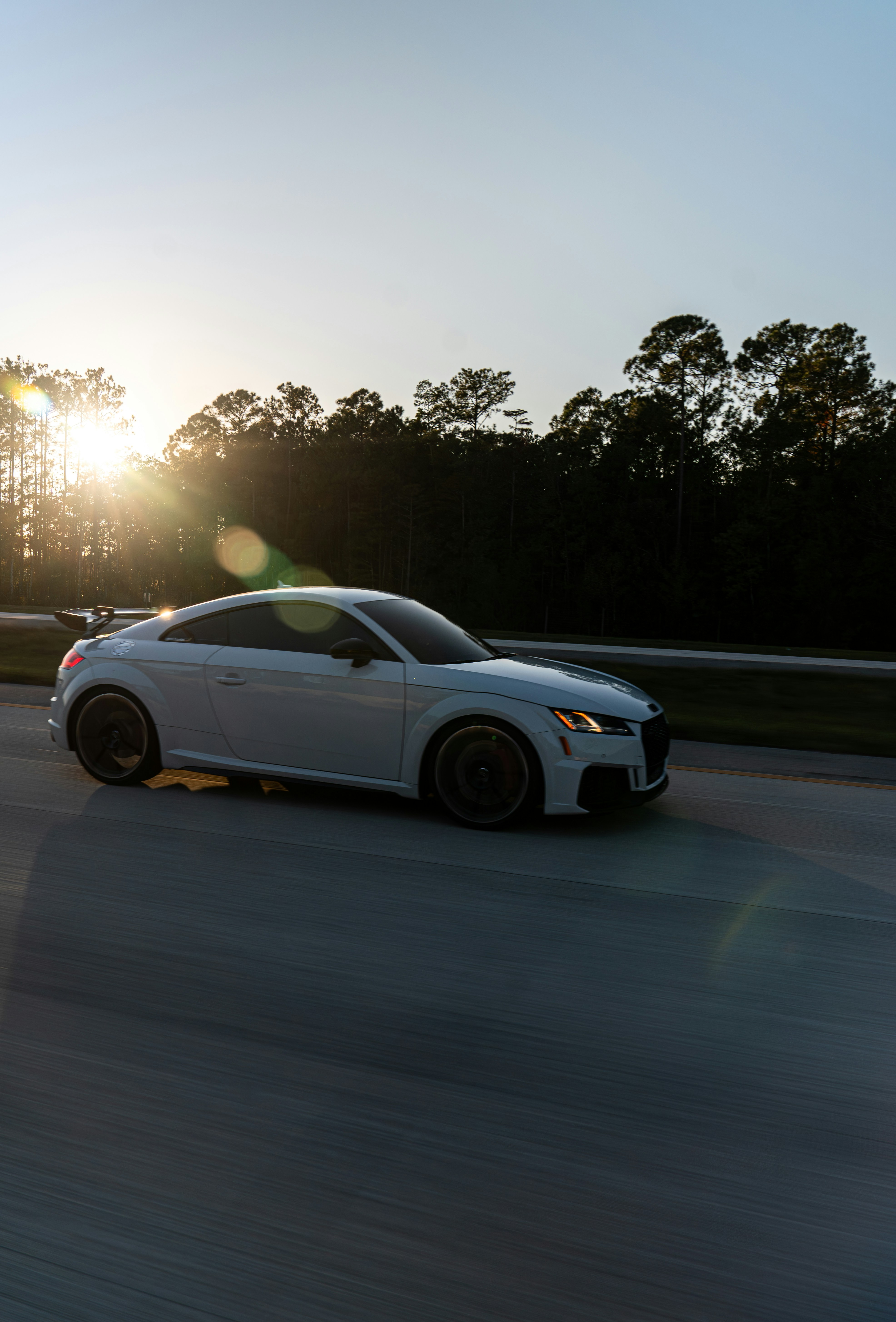 A white sports car driving down a road photo – Free Mountains Image on ...