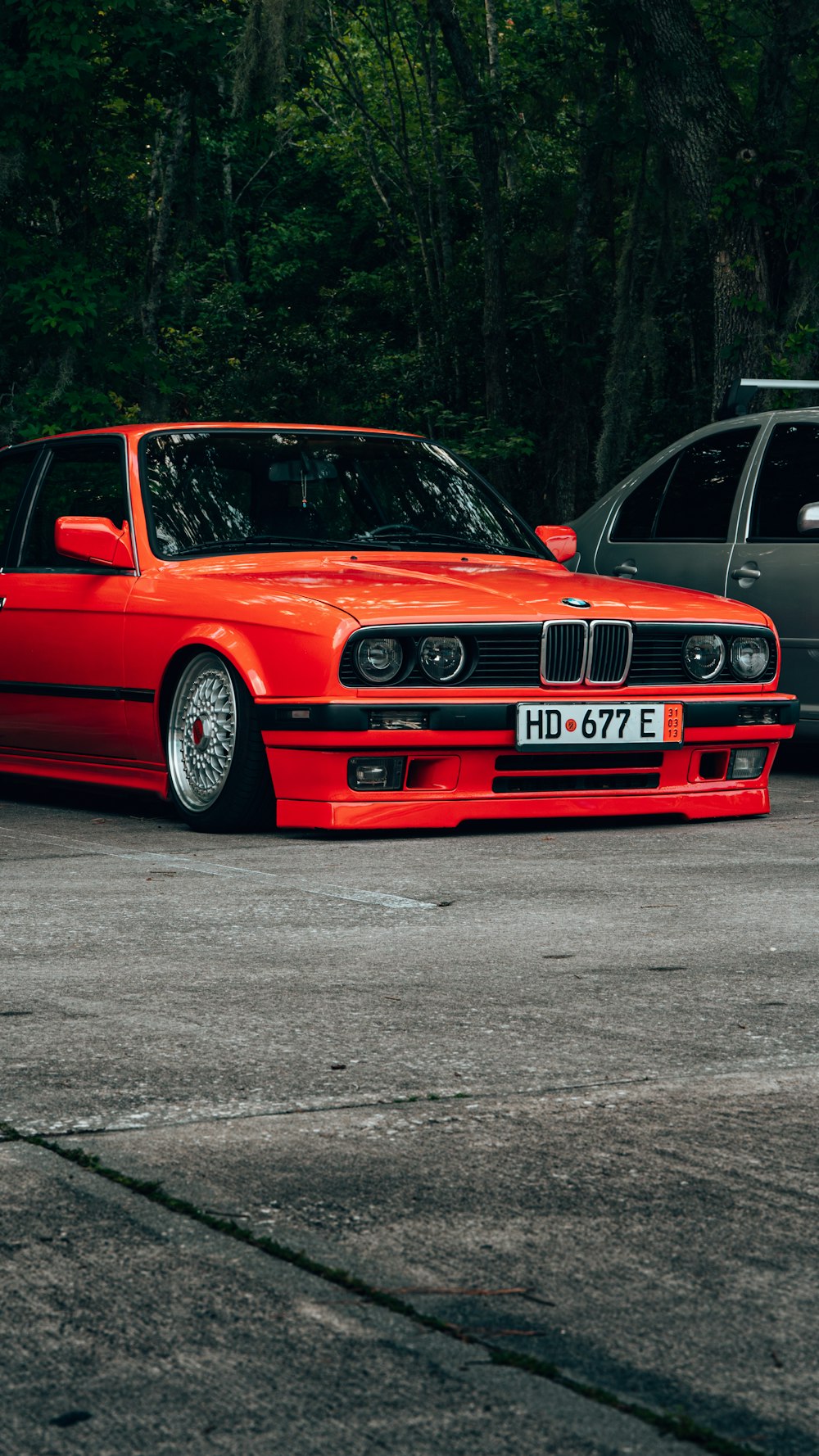 a red bmw is parked in a parking lot
