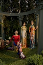 a group of women standing next to each other on a lush green field
