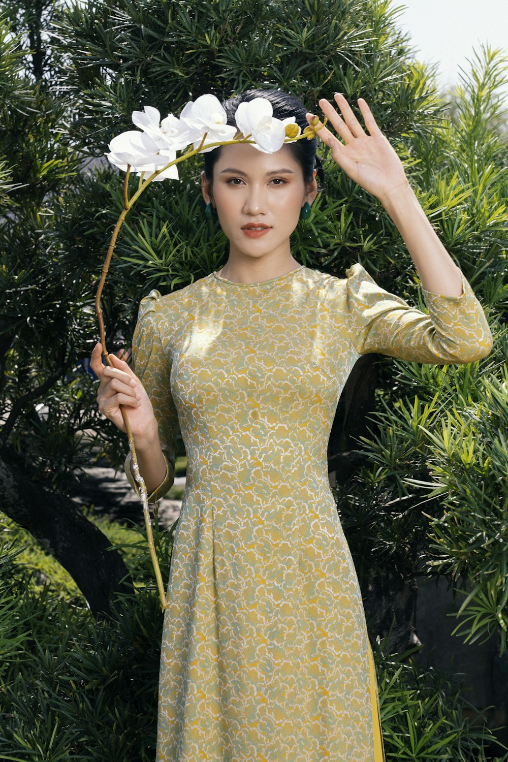 a woman in a yellow dress holding a flower