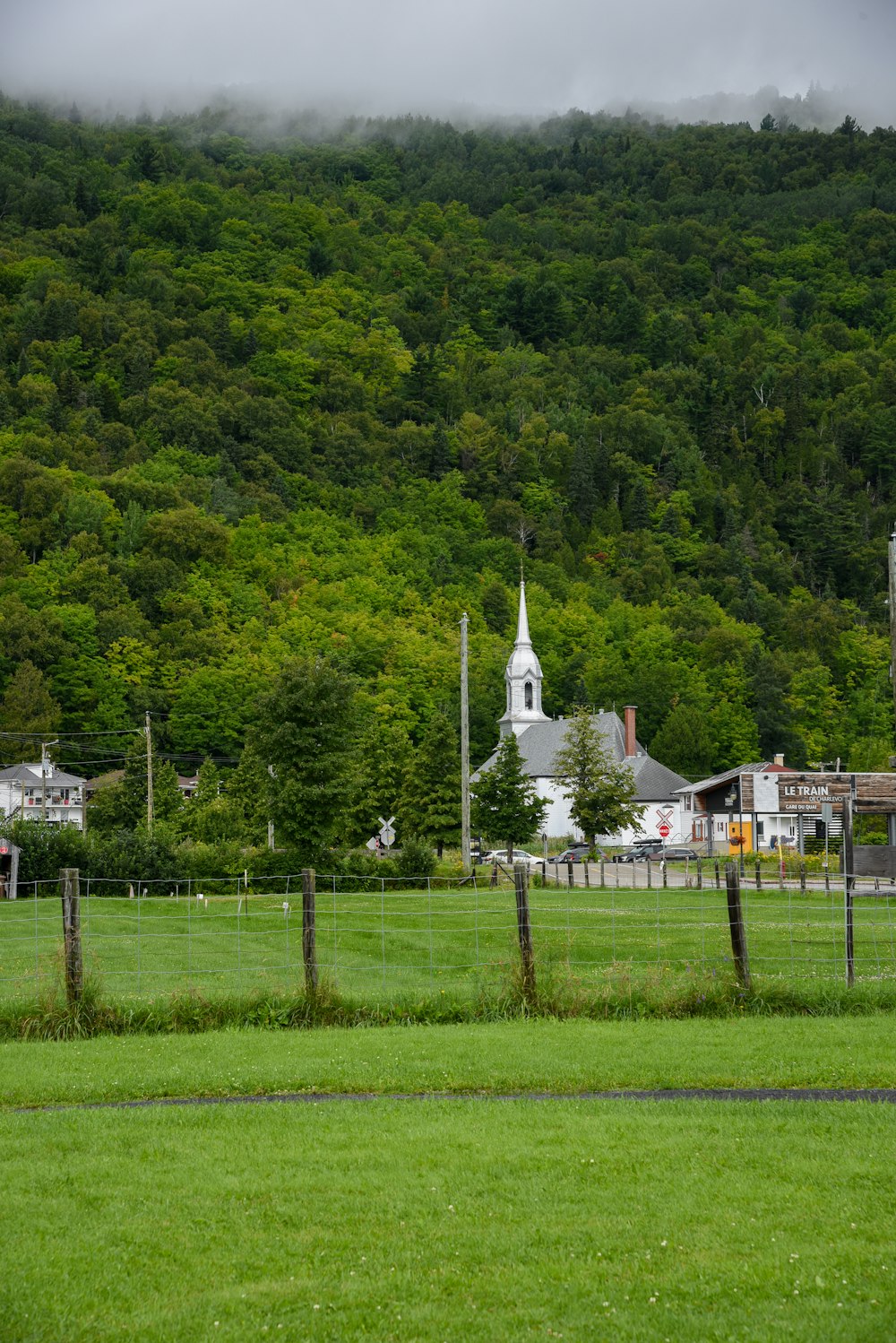 a green field with a church in the background