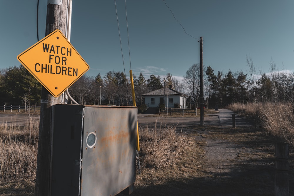 a watch for children sign on a telephone pole