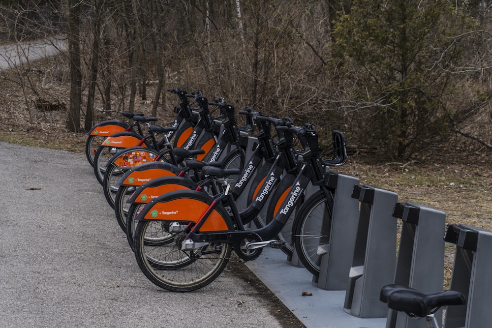 a row of bikes parked next to a metal fence