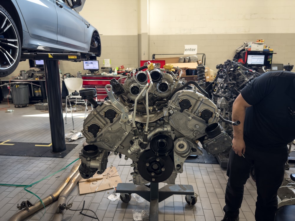 a man working on a car engine in a garage