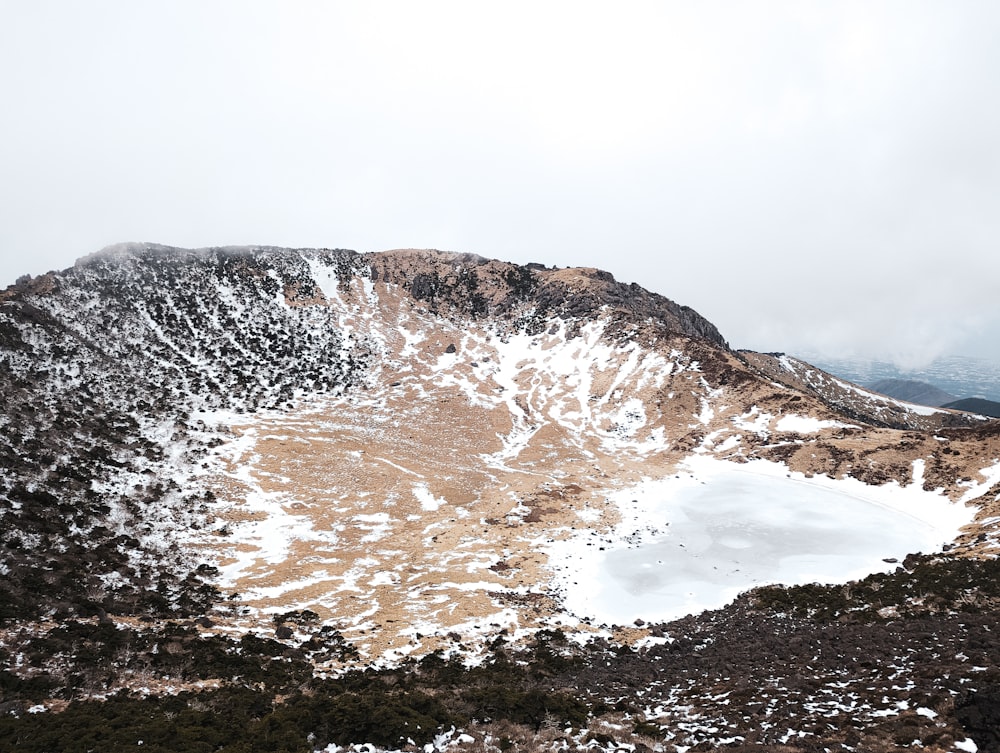 ein schneebedeckter Berg mit einem See in der Mitte