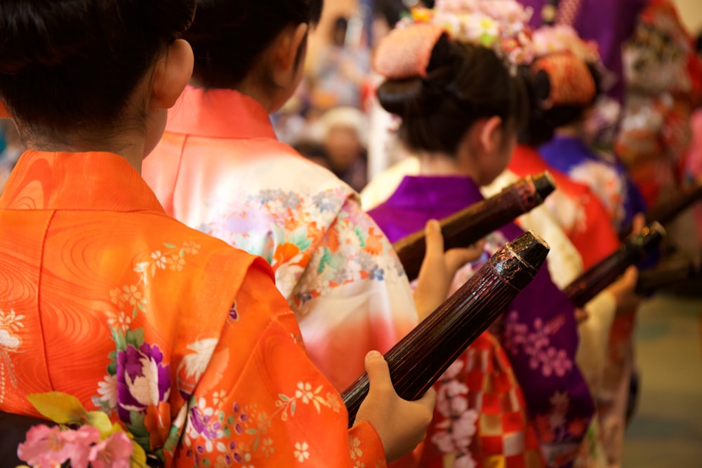 a group of women in kimonos holding umbrellas