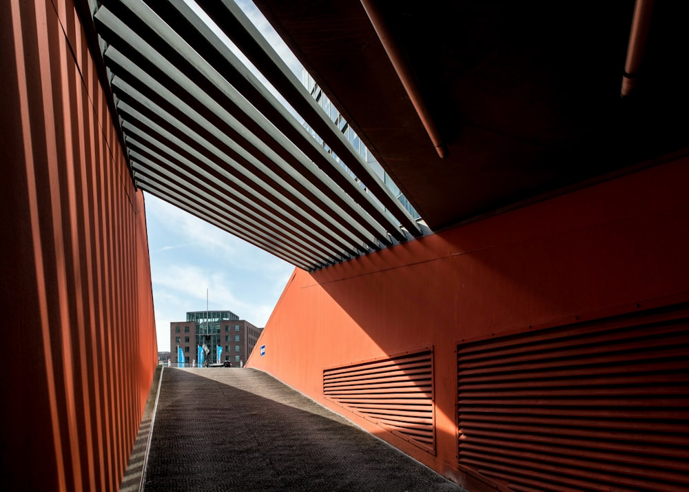 a walkway between two buildings with a sky background