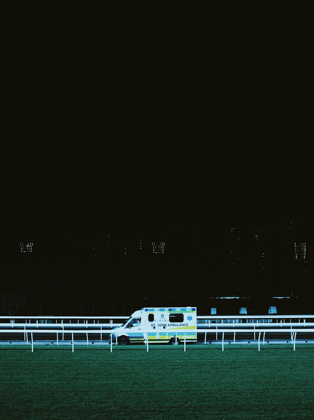 a horse race track at night with a white truck on it