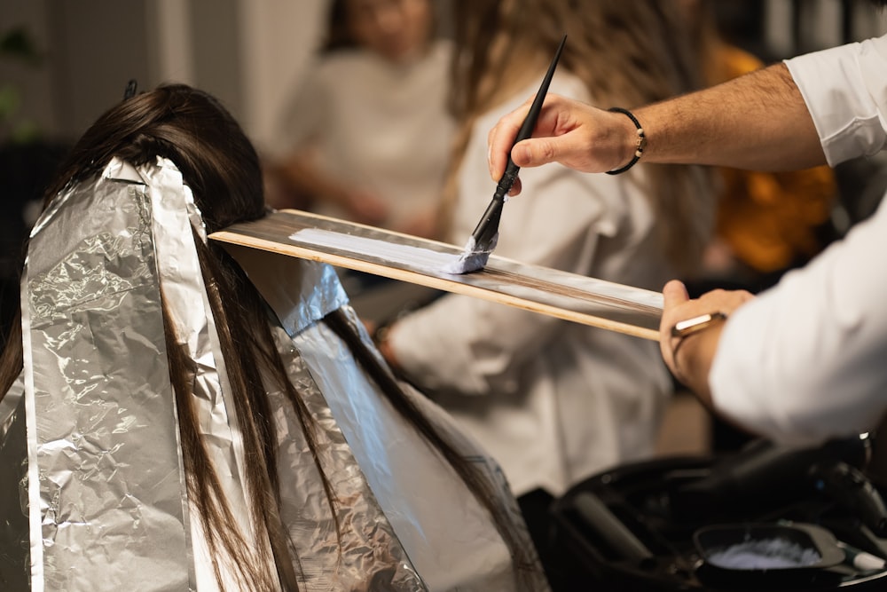 a man cutting a woman's hair with a pair of scissors