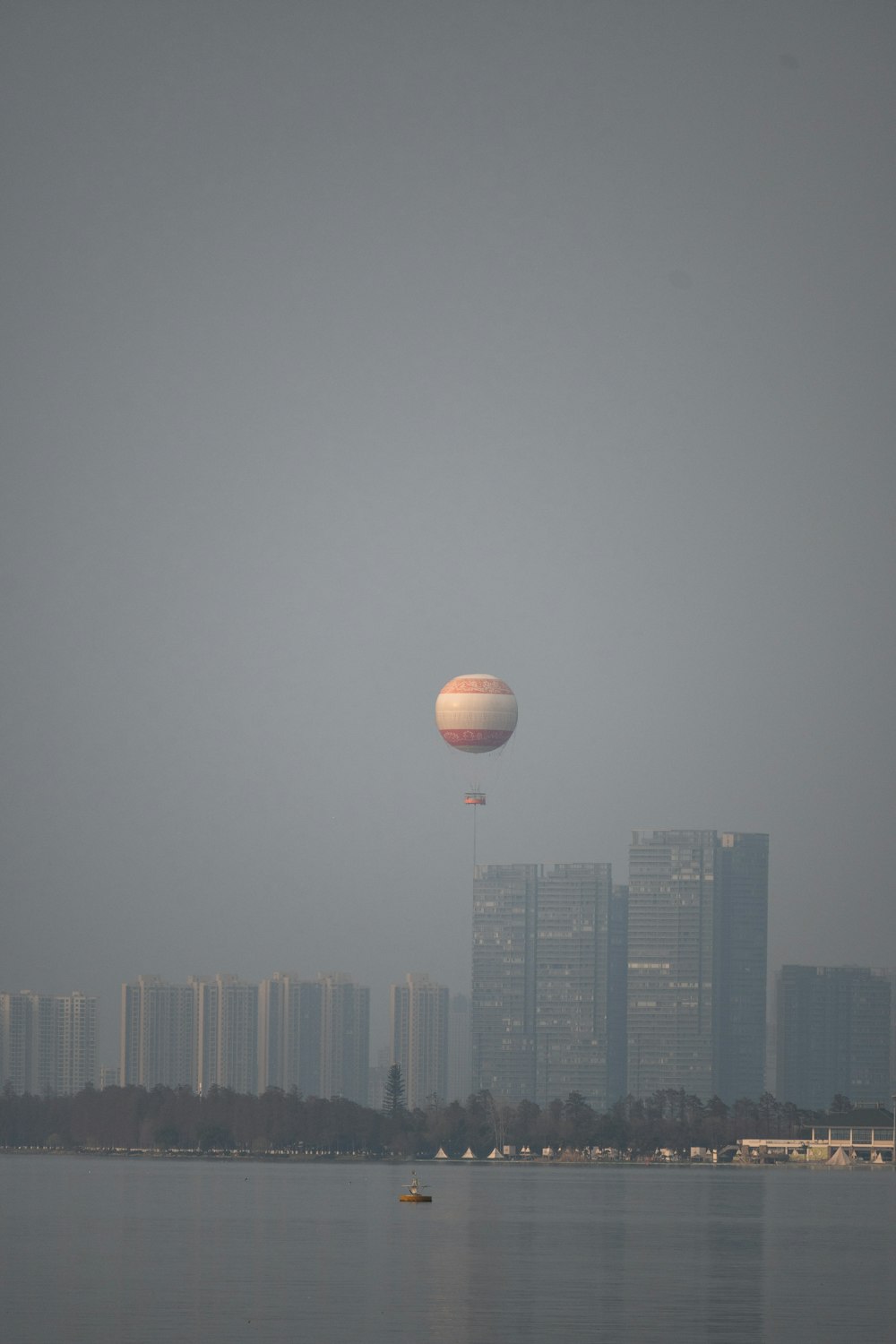 a large balloon flying over a large body of water