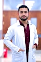 a man in a lab coat standing with his hands on his hips
