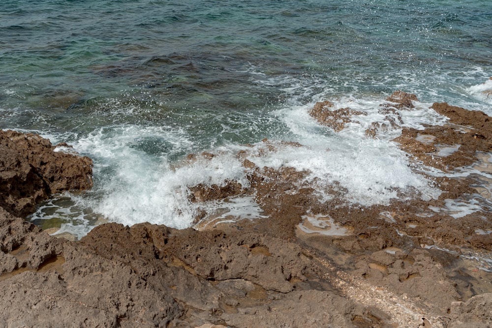a rocky shore with waves crashing against the rocks