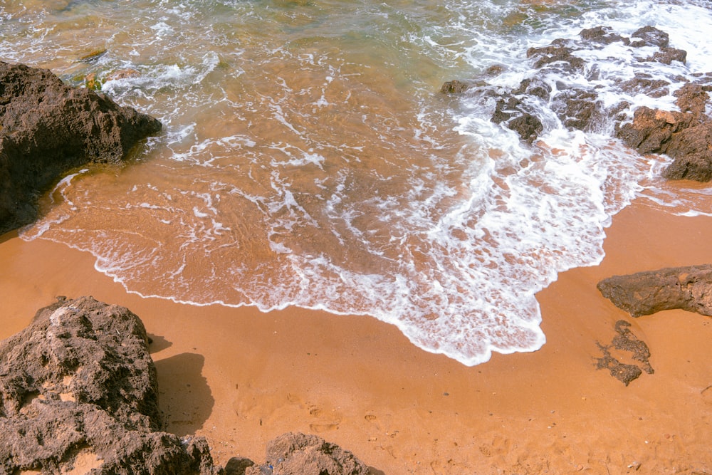 a sandy beach with waves coming in to shore