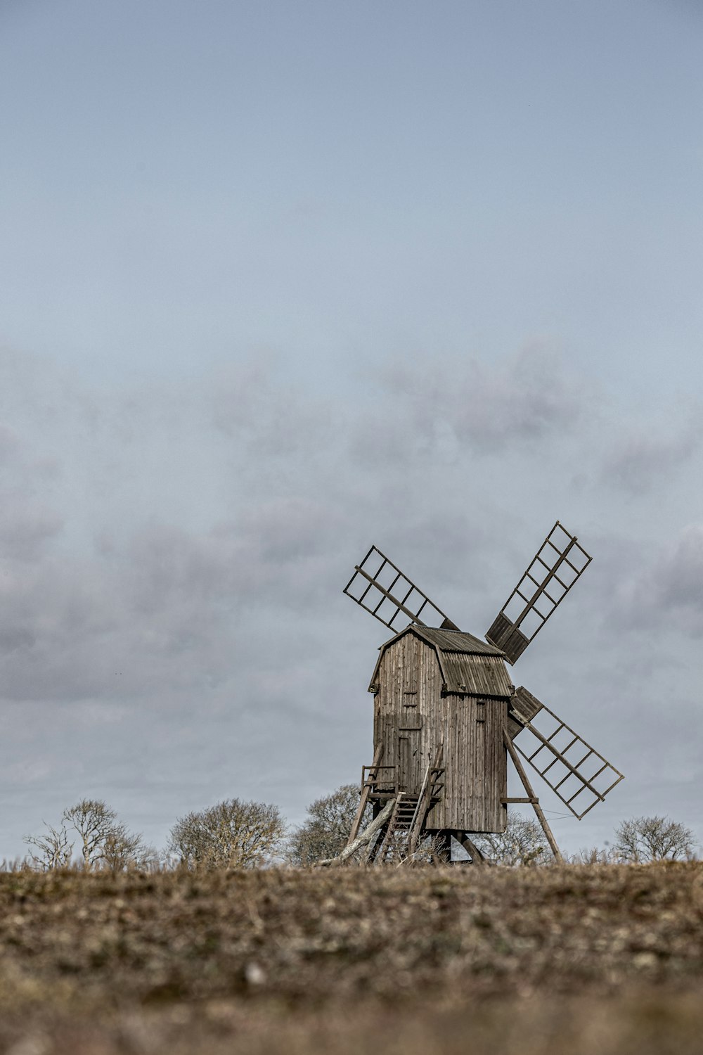 eine Windmühle auf einem Feld mit Himmelshintergrund