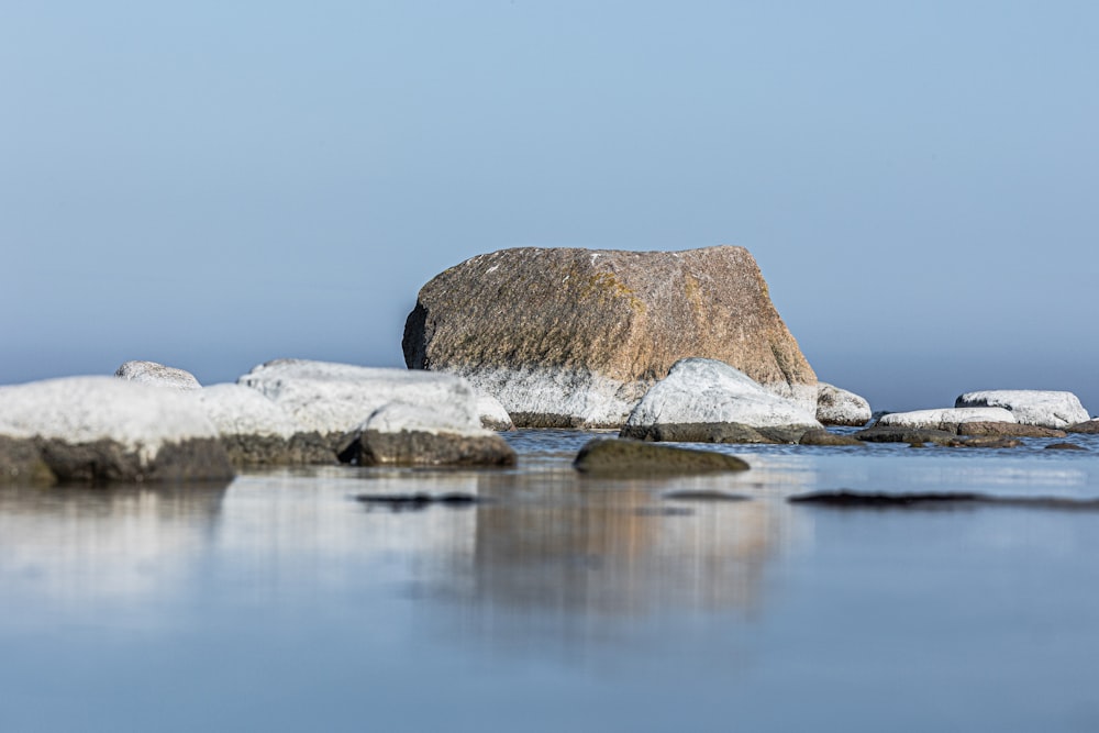 a large rock sitting on top of a body of water