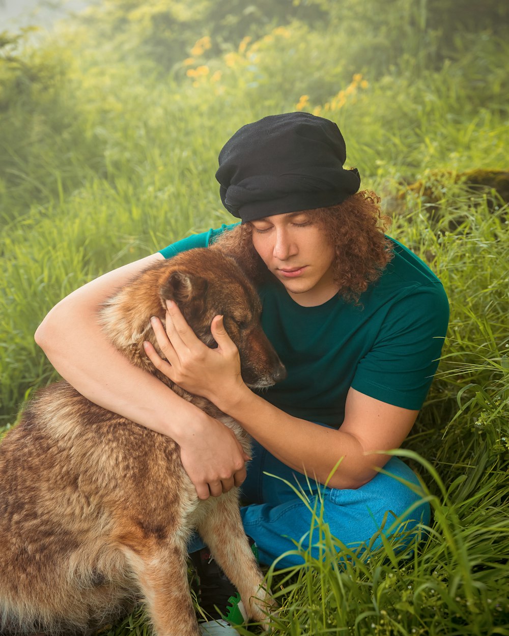 a man sitting in the grass with his dog