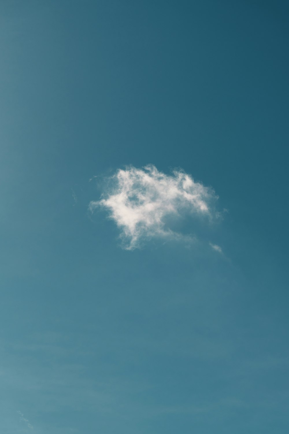 a lone cloud in a blue sky
