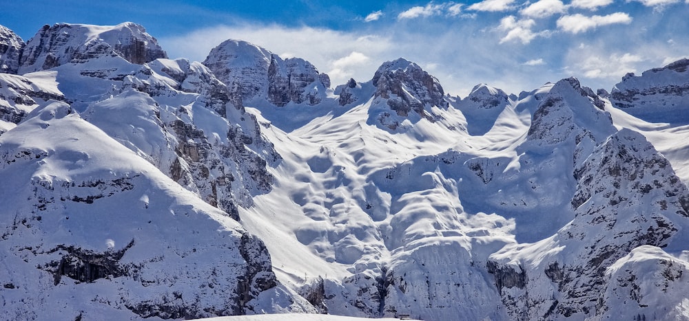 a mountain range covered in snow under a blue sky