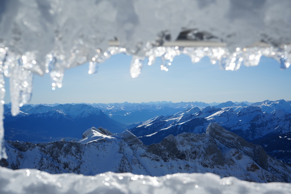 a view of a snowy mountain range from a window