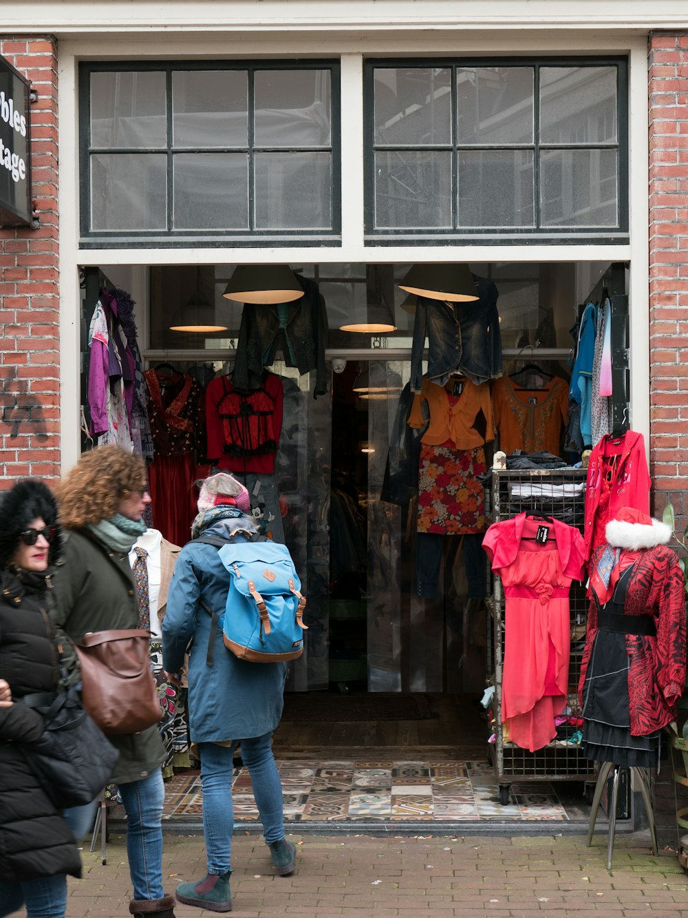 a group of people standing outside of a clothing store