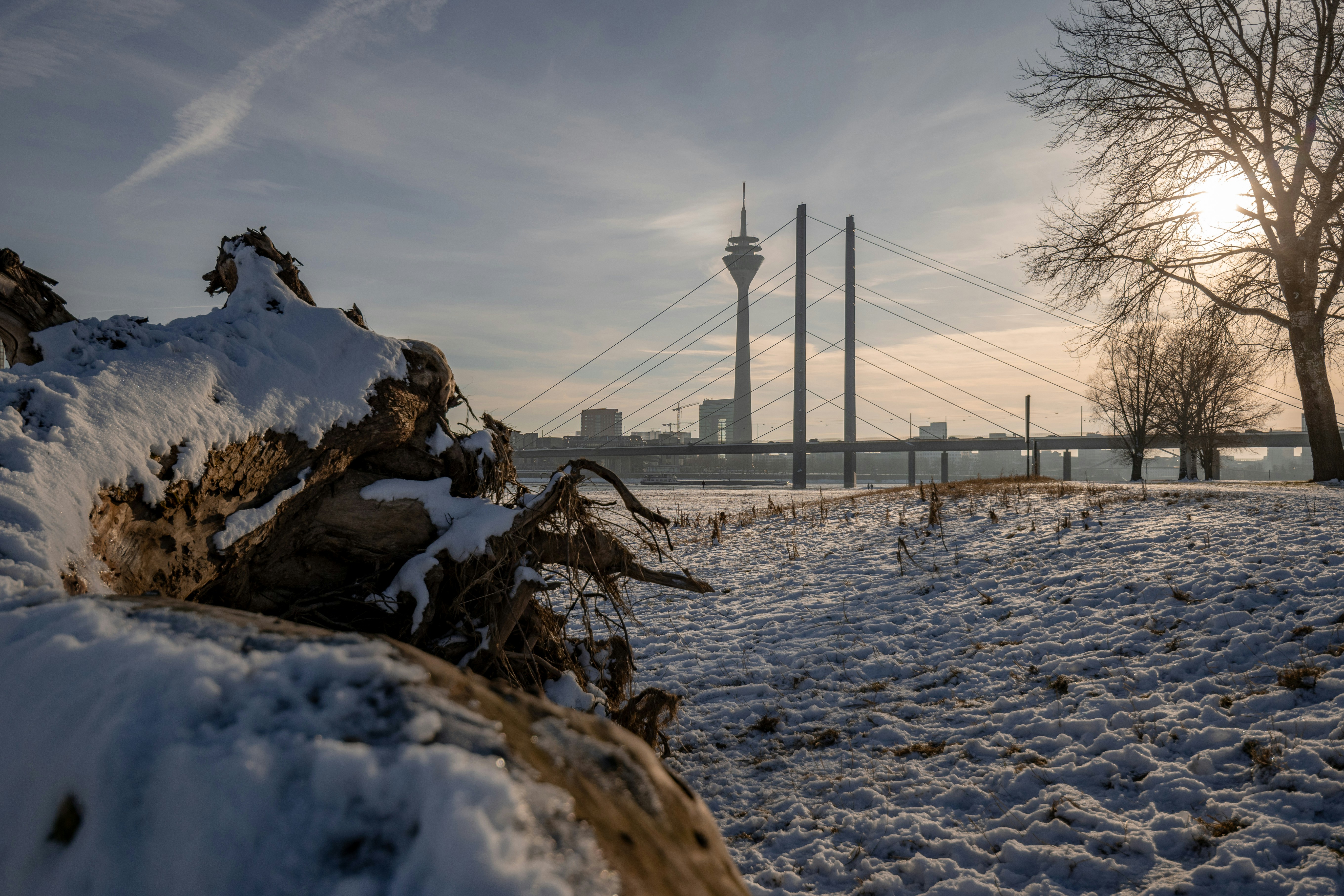 ein schneebedecktes Feld mit einer Brücke im Hintergrund