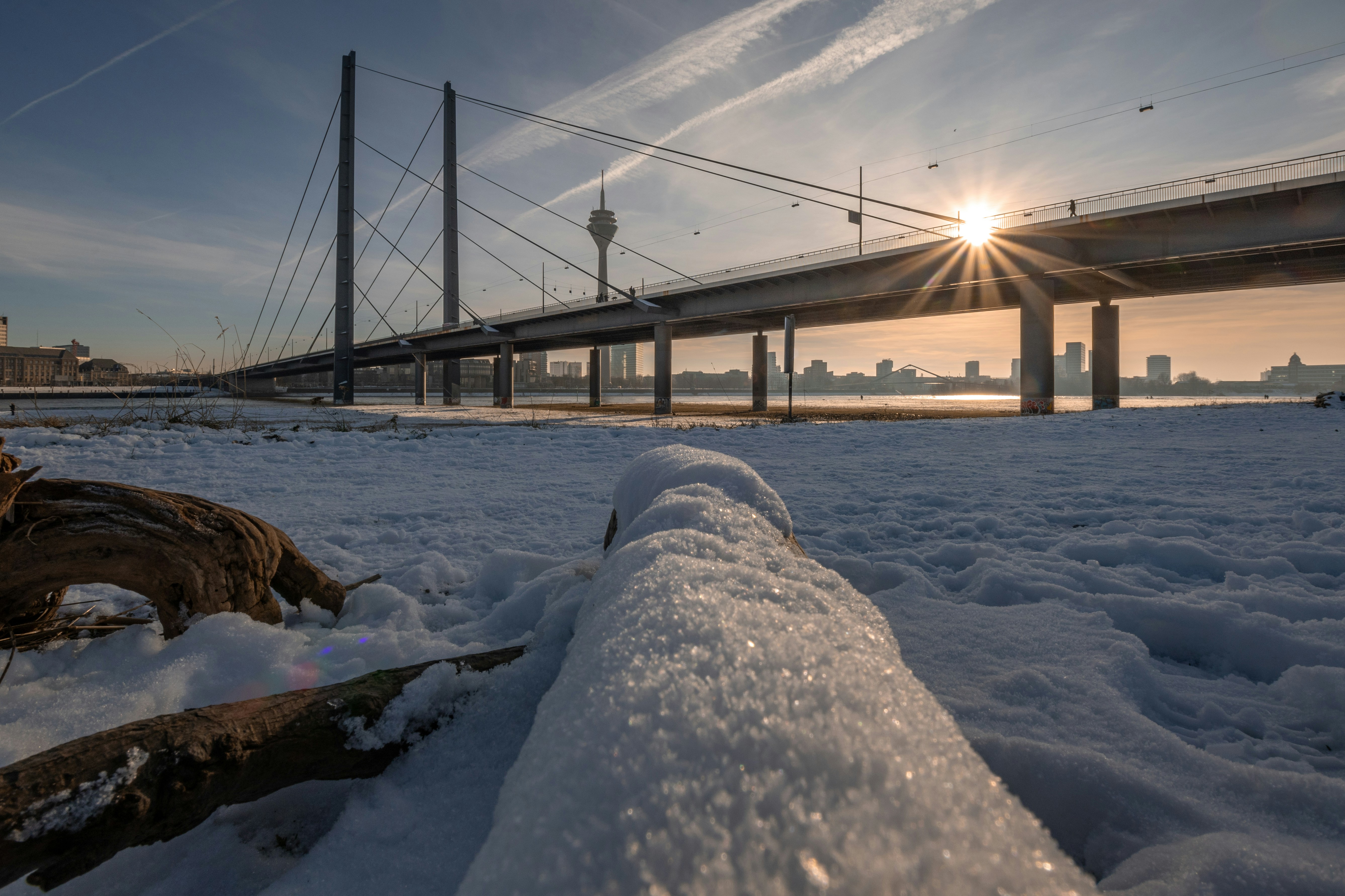 Die Sonne scheint über eine Brücke über Schnee