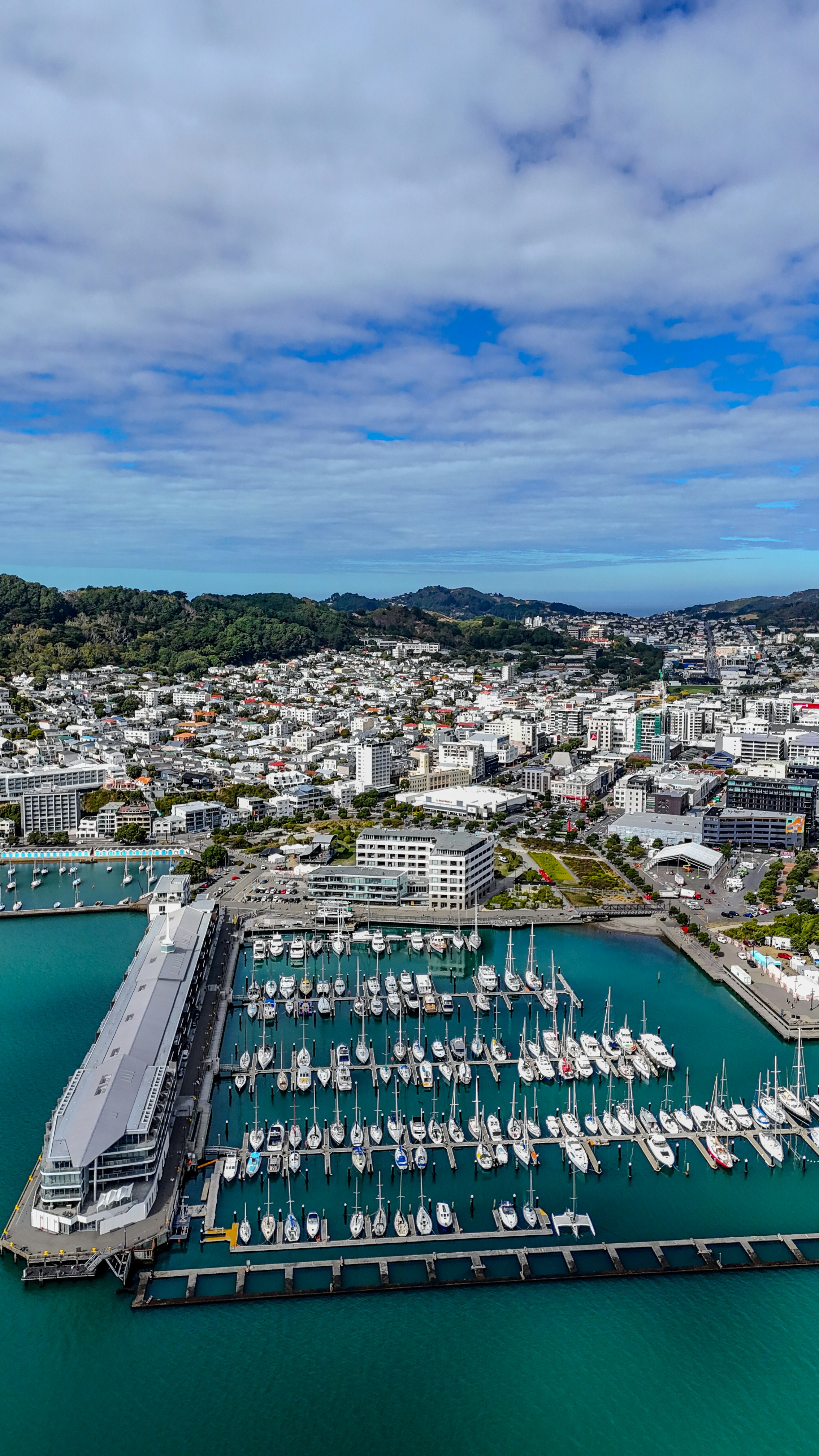 Santa Barbara Harbor with sailboats, fishing vessels and blue sky, aerial view of the marina and coastline