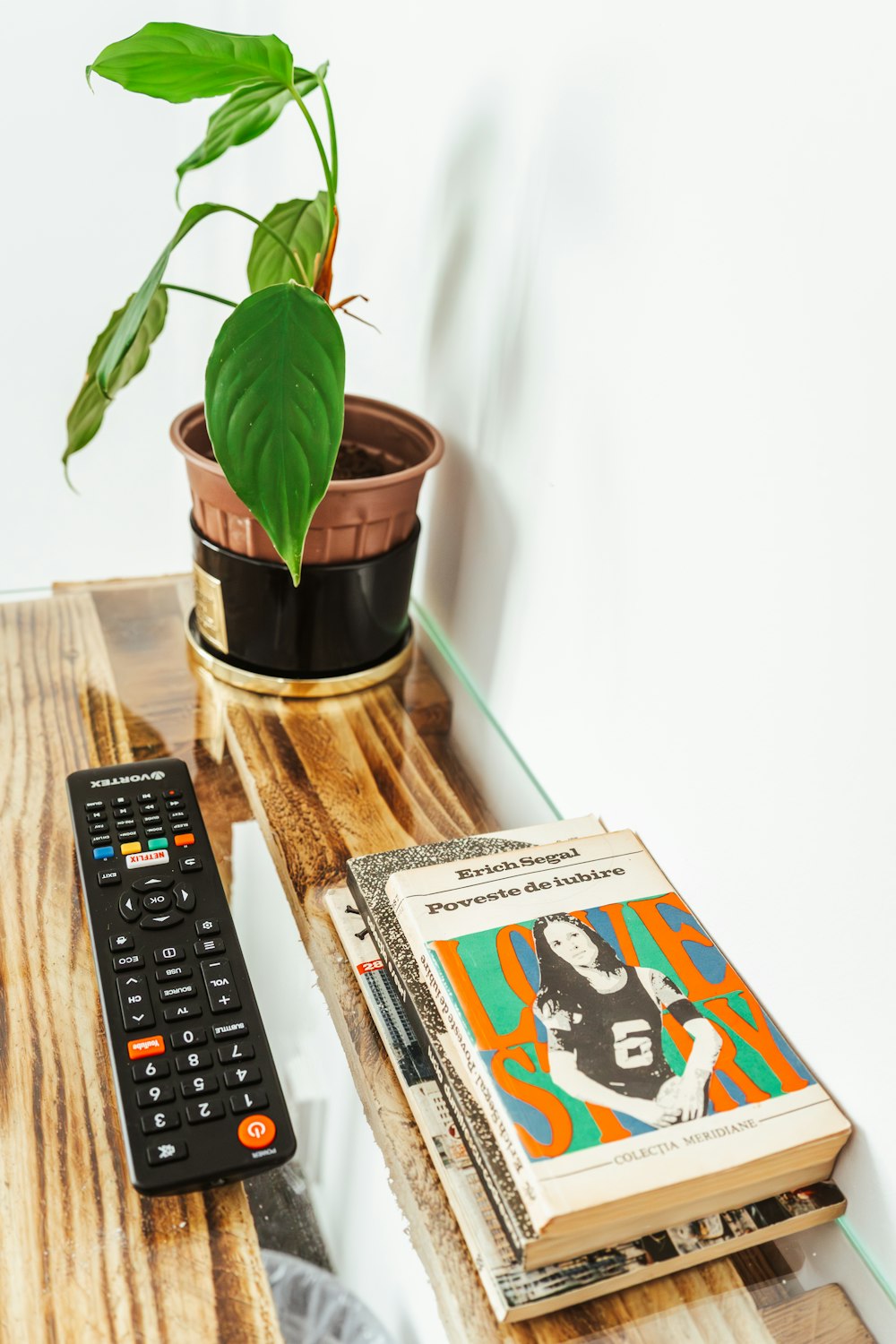 a wooden table topped with a remote control and a book
