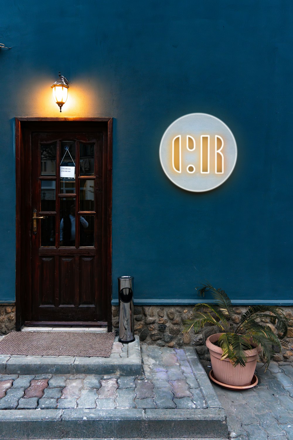 a blue building with a door and a sign on it