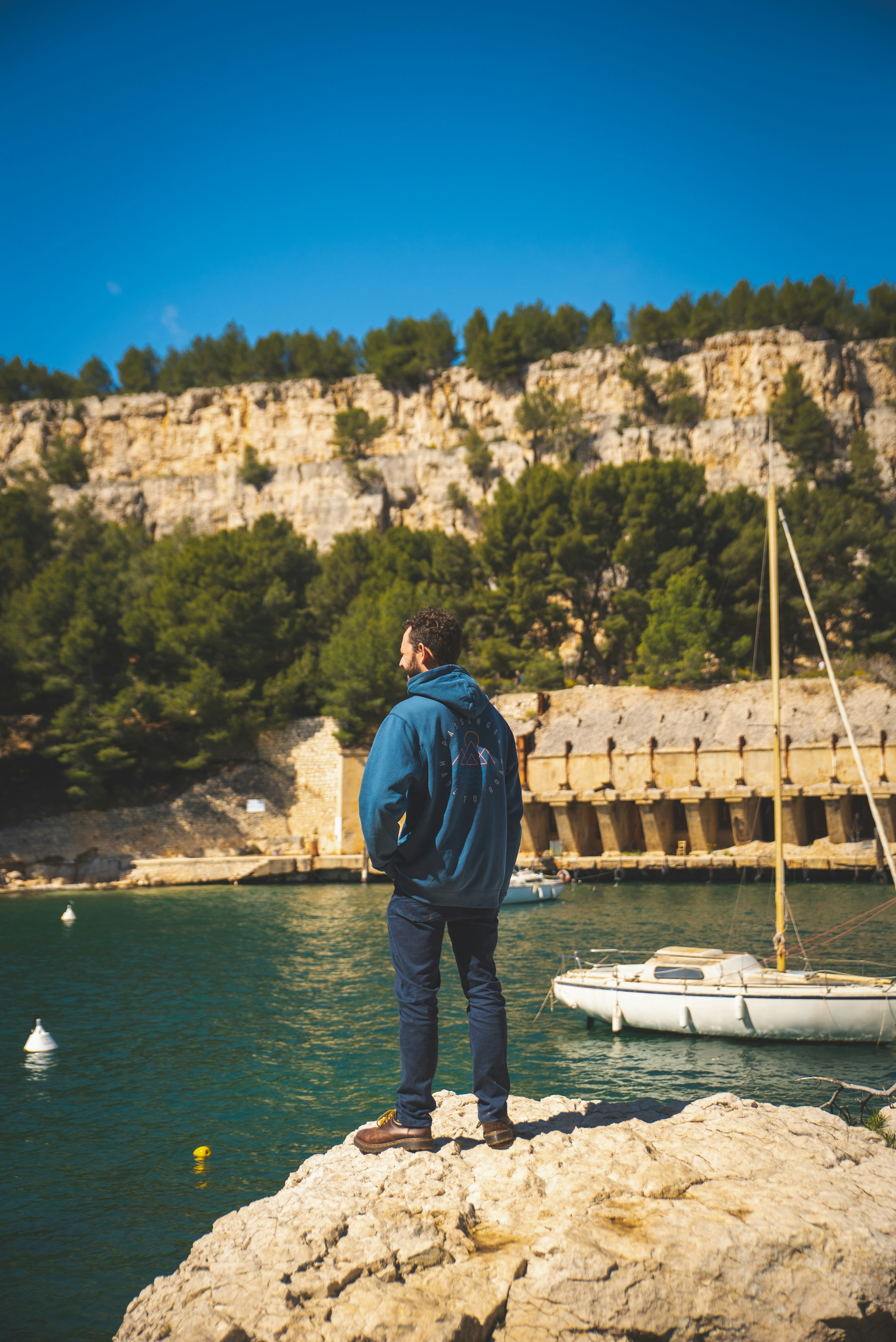 a man standing on a rock overlooking a body of water