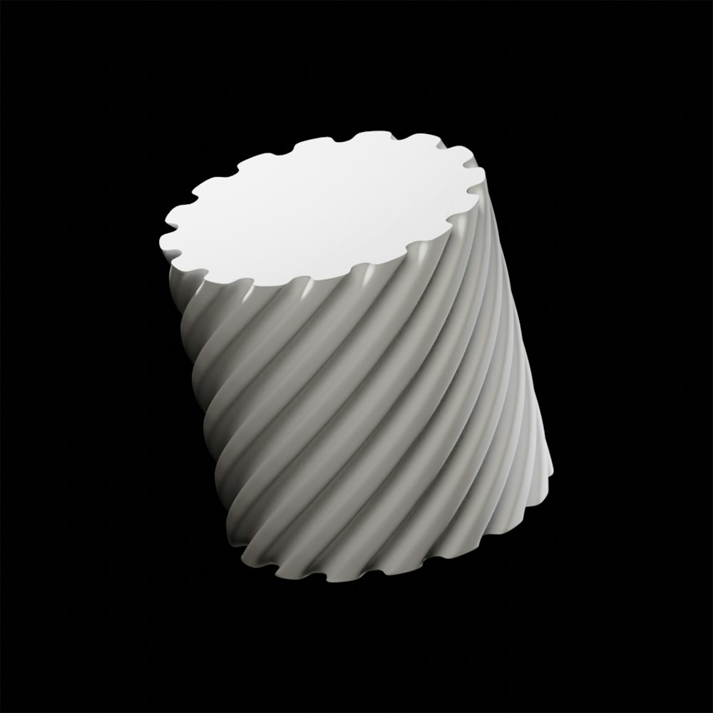 a white vase sitting on top of a black table