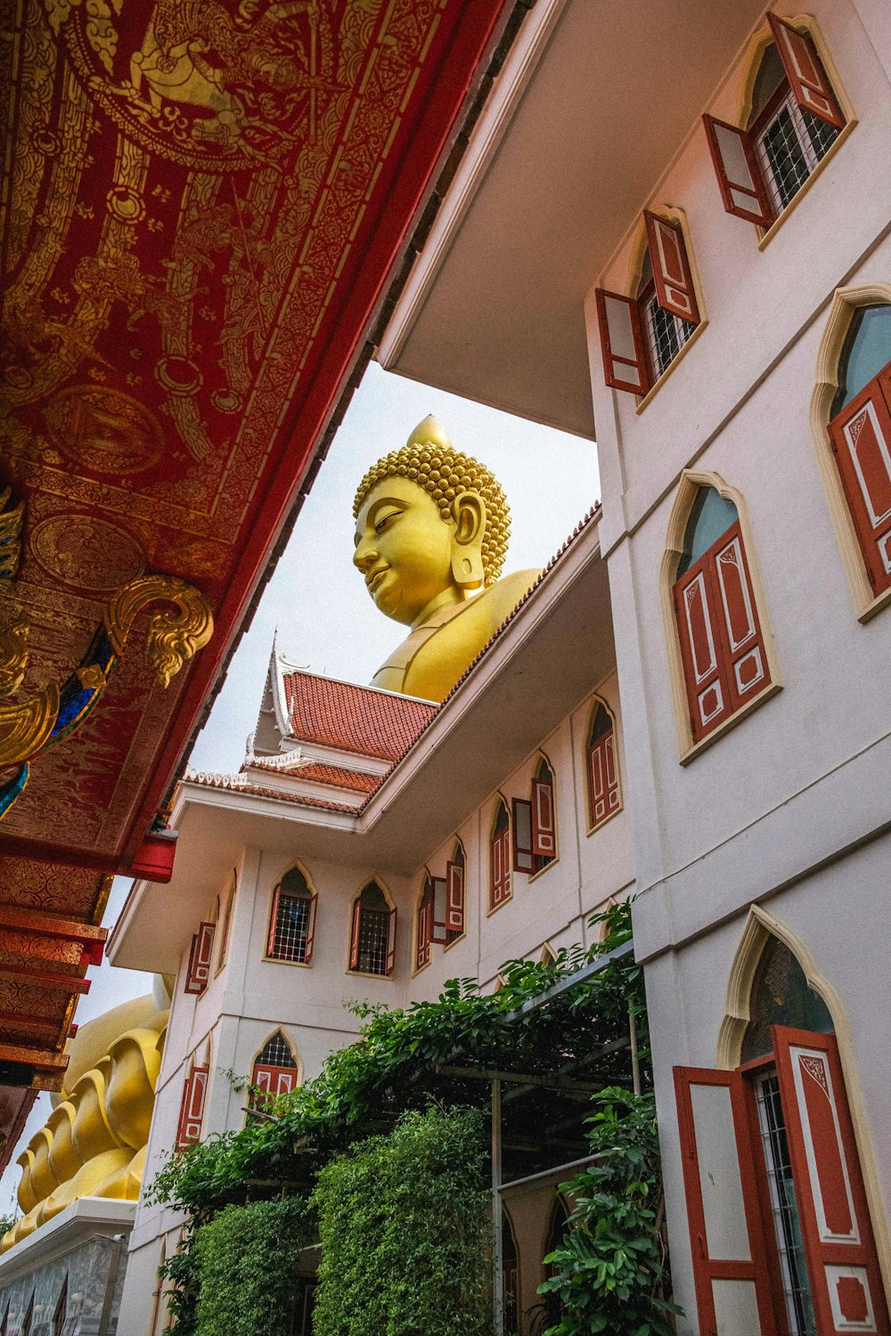 a large golden buddha statue sitting in front of a building